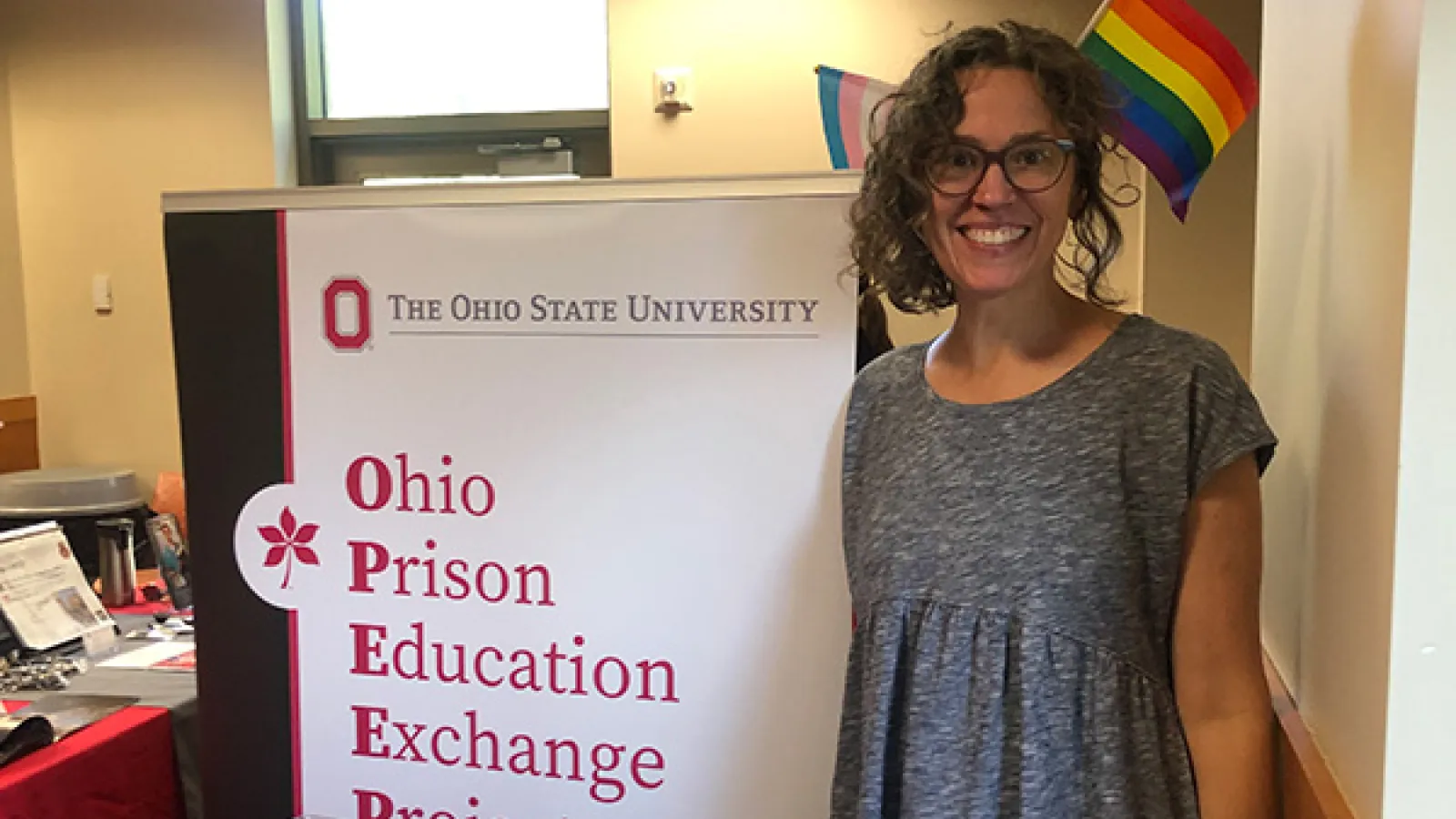 OPEEP Co-Director Dr. Mary Thomas proudly wears LGBTQ+ flags in her hair while standing next to the OPEEP sign at the Newark student fair.