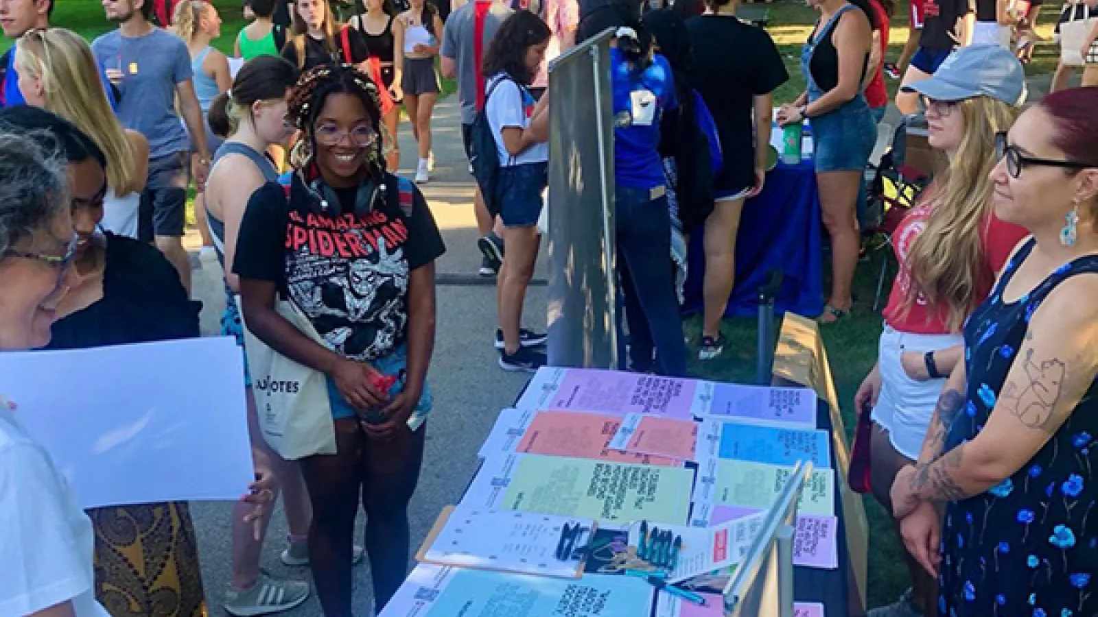Students at the Columbus campus student involvement fair smile as they chat with OPEEP staff and co-directors about the project's work and course offerings.