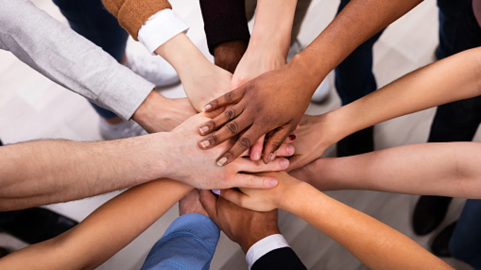 Group of diverse hands stacked together in unison