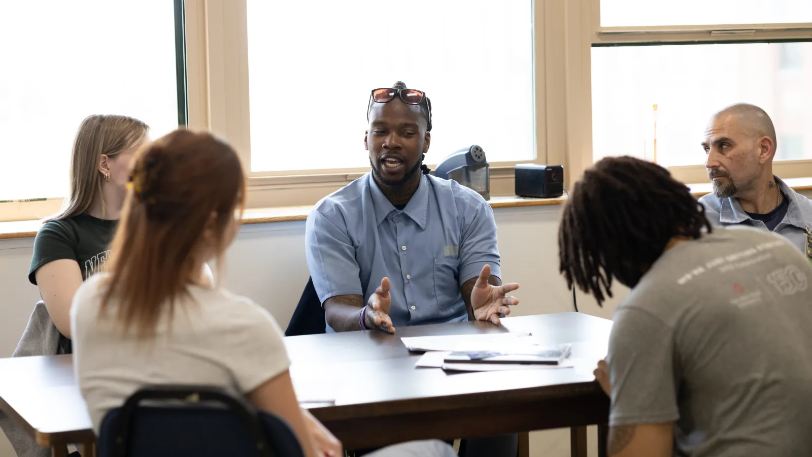 5 students, 3 campus-based and 2 incarcerated, sit around a table for a class discussion in Dr. Terrance Hinton's Spring 2024 Corrections class held at London Correctional Institution.
